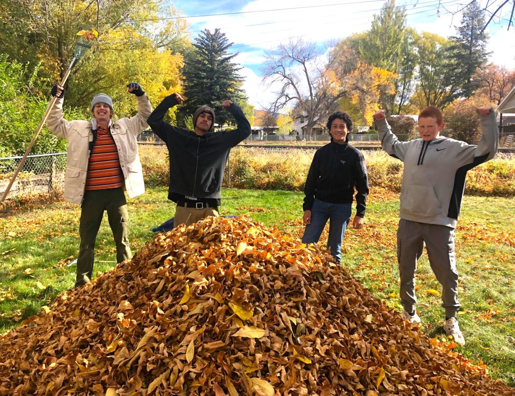 teens raking leaves for senior
