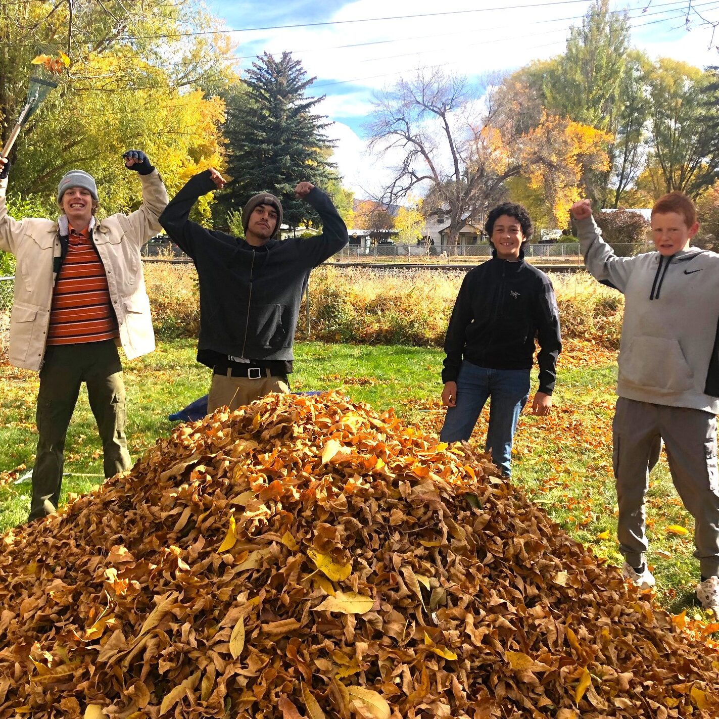 teens raking leaves for senior